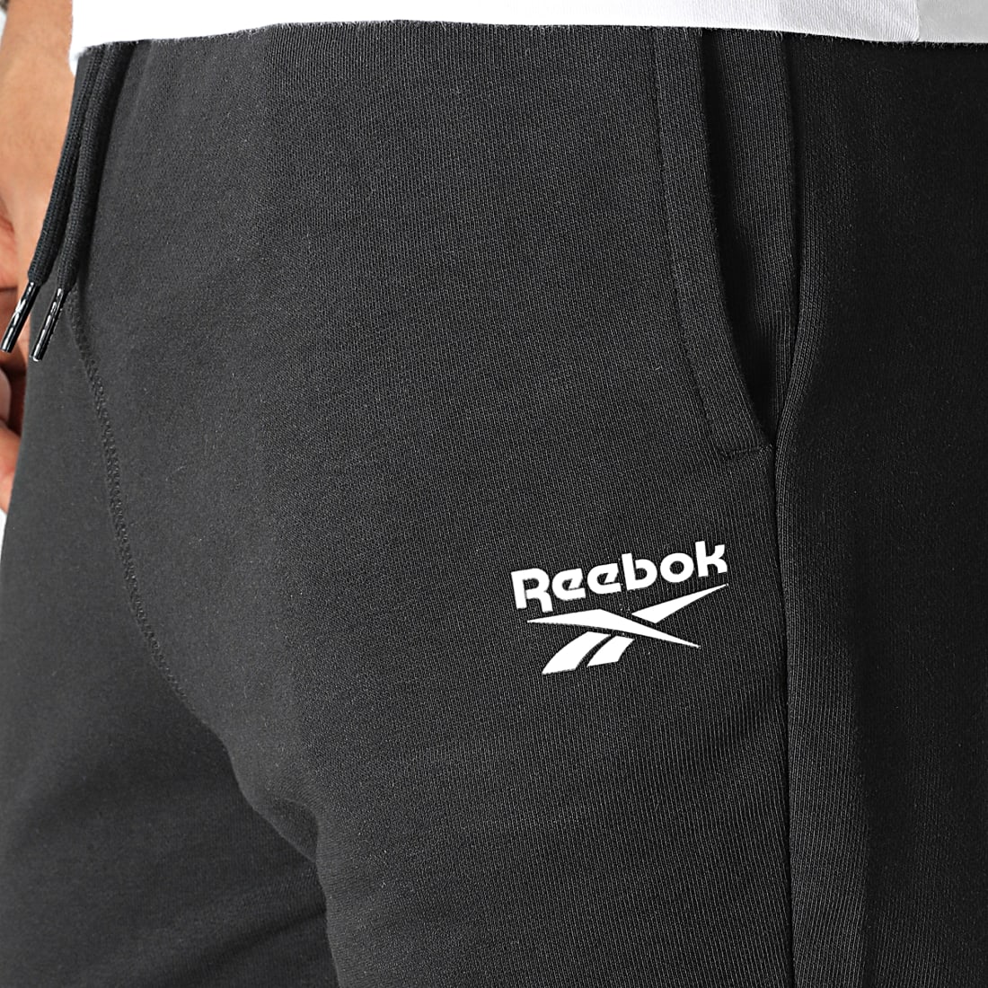 Pantalon jogging homme Reebok, taille M, coloris noir, entièrement doublé,  2 poches en biais sur les cotés, ceinture et bas de jambes élastiqués,  lacet Reebok de serrage à la taille, à l'intérieur.
